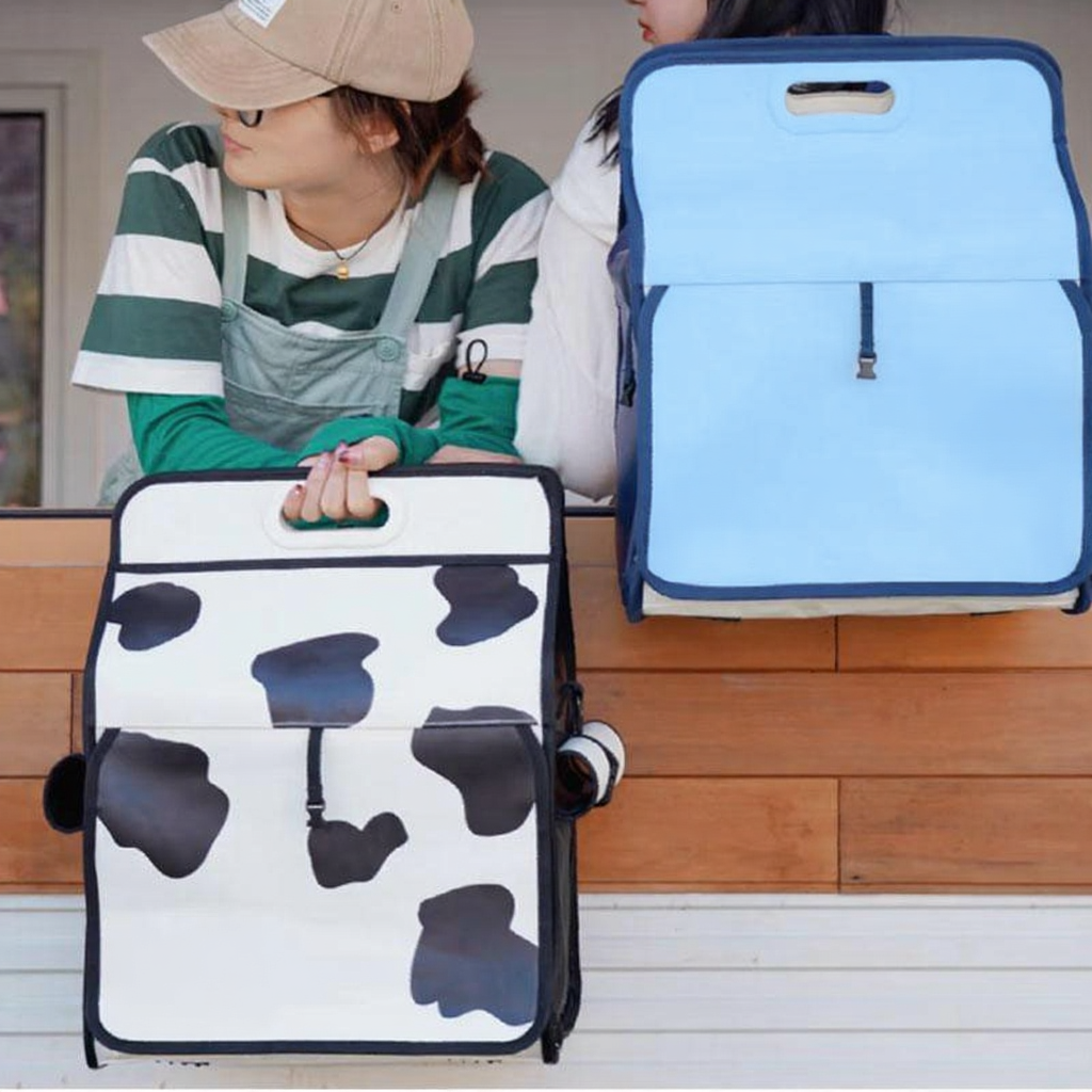 Catvera Milk Carton Cat Carrier - Image 11|||PROMPT|||Cleaned image. Original analysis: Found 3 brand names printed directly on the products: 'milk' with 'designed by purpy' on the cow-print bag (left), 'milk' on the blue bag (right), and a milk carton icon with '2500 ml' capacity marking on the blue bag