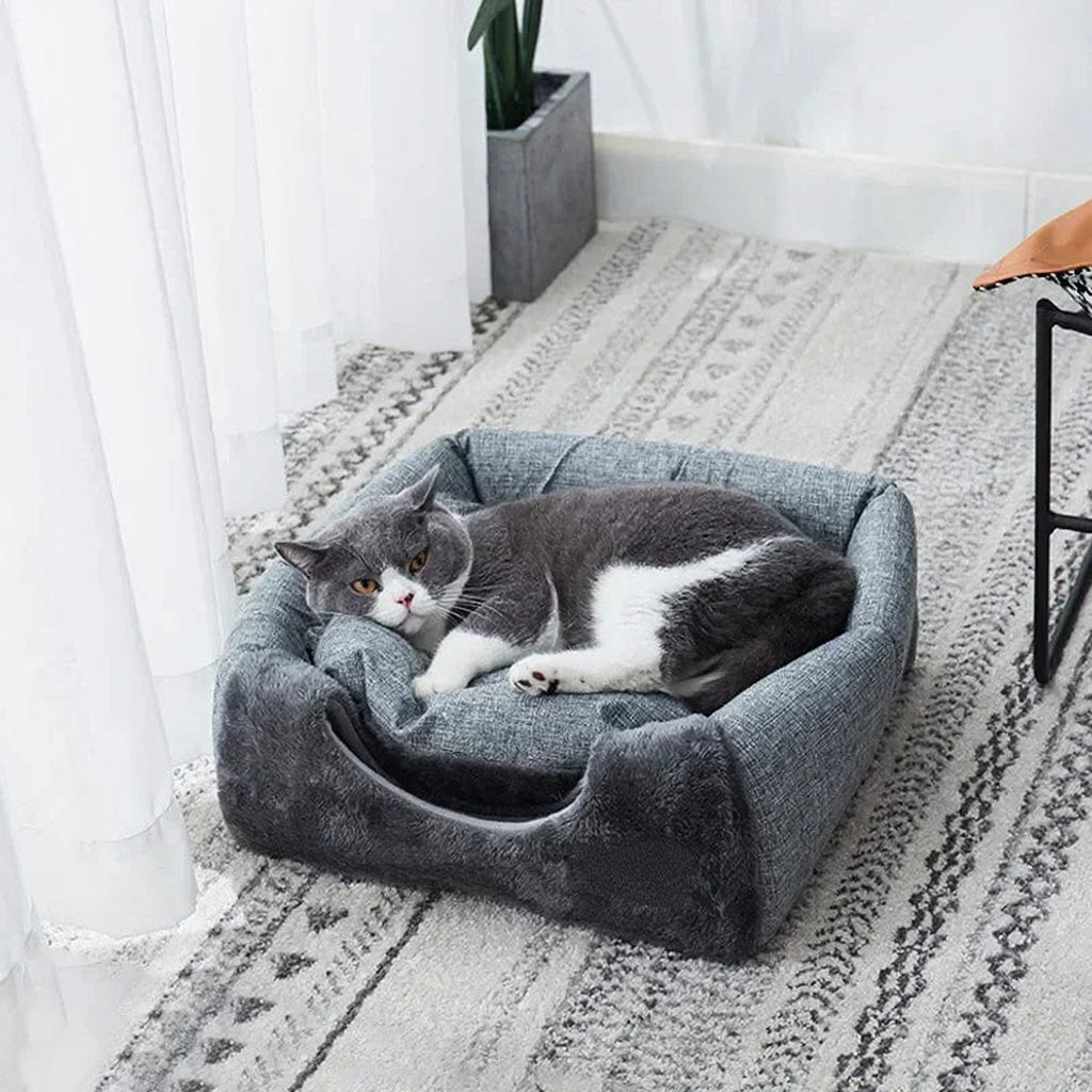 Catvera Triangle Enclosed Cat Nest - Image 3|||PROMPT|||Cleaned image. Original analysis: Found 1 brand name tag on the pet bed. There is a brown/tan branded label tag stitched directly onto the gray fabric bed.